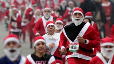 People running in Santa costumes