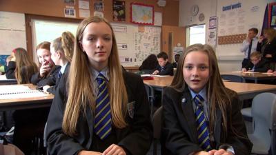 Two school pupils sat next to each other