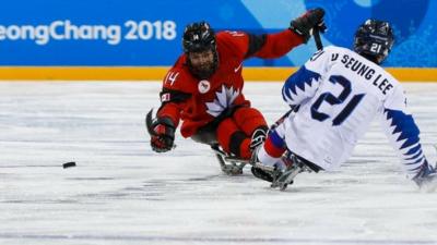 South Korean ice-hockey player tackles a player from Canada