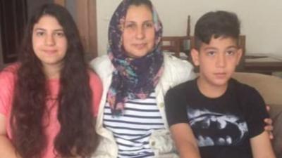 Sema Sertçelik, wife of coup victim Akin, and her two children.