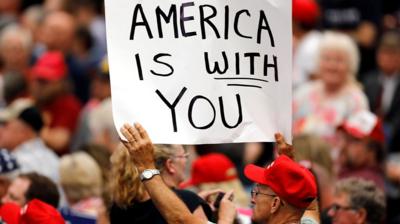 A Trump supporter holding a sign at an Iowa rally