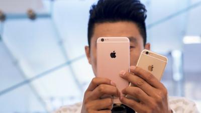 A man takes pictures as the Apple iPhone 6s and 6s Plus go on sale at an Apple Store in Beijing, China, September 25, 2015.