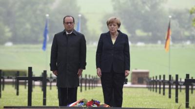 French President Francois Hollande and German Chancellor Angela Merkel pay their respects after laying a wreath.