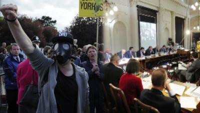 Protestors demonstrating against fracking and a council meeting.