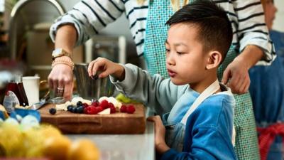 Child and adult preparing food