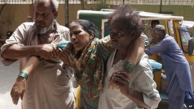 Family members take a woman to hospital suffering from heatstroke in Karachi, Pakistan