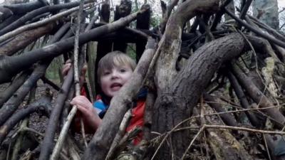 Boy playing in branches