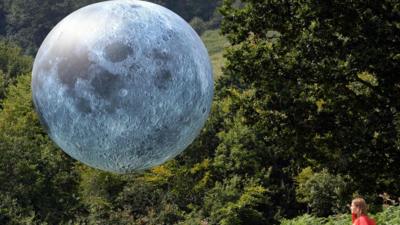 girl looking at moon balloon