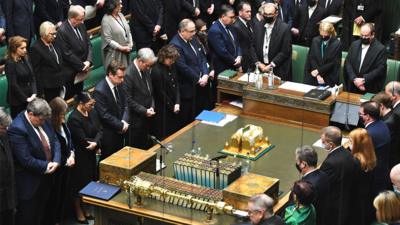 MPs with bowed heads in House of Commons