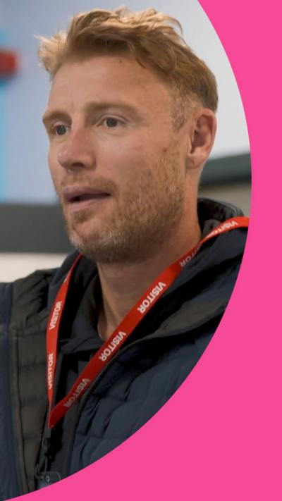 Freddie Flintoff stands in a classroom wearing a puffer jacket