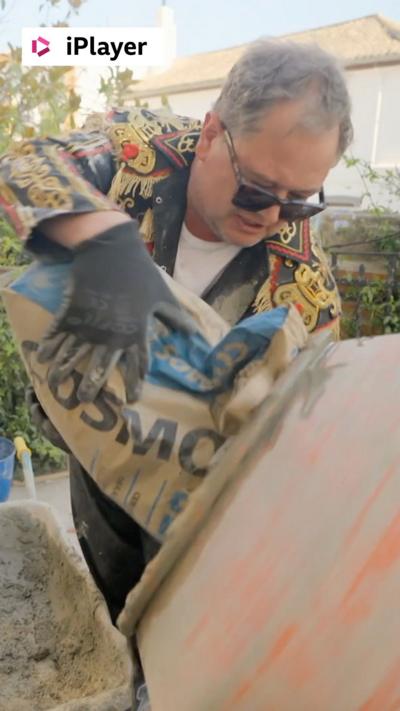 Alan Carr pours cement into a mixer