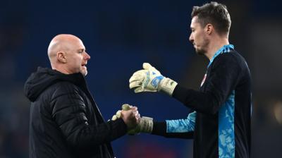 Robert Page shakes hands with Wayne Hennessey