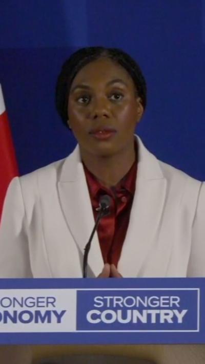 Kemi Badenoch speaking from podium with words that read 'stronger country'