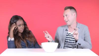 Man and woman sat at table, the woman looks into middle distance