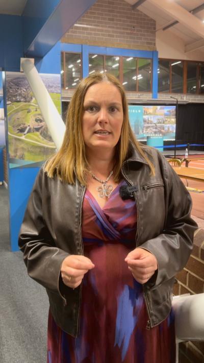 A woman with blonde hair looks into the camera