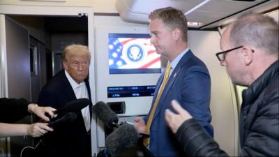 Donald Trump talks to reporters on Air Force One.