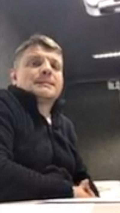 A man looking towards a camera on a grainy shot