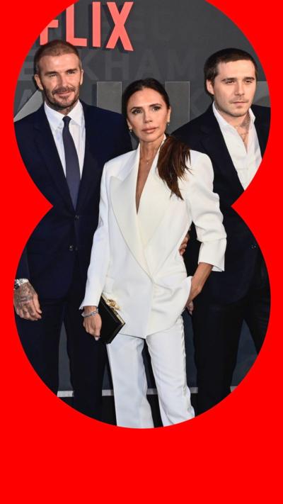 David, Victoria and Brooklyn Beckham at a Netflix premiere, all wearing suits.