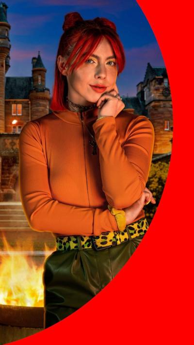 A promotional image of Jessie Stride in front of The Traitors castle