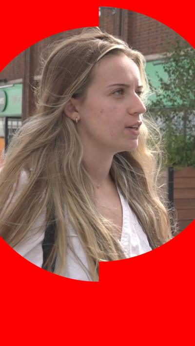 A young woman looking to the right, speaking. The image also has a red graphic mask over it, meaning it is in the 'News' category.