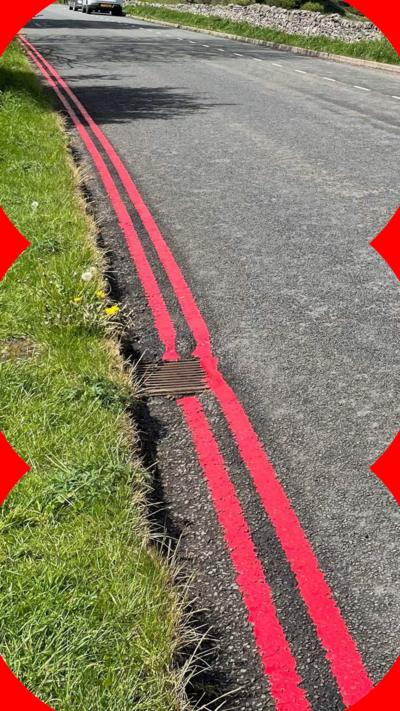Double red lines painted on a road in the Peak District.