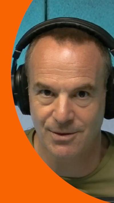 Martin Lewis wearing headphones looking at camera