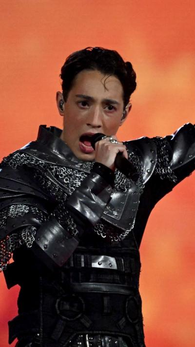 Norway's Eurovision act Kyle Alessandro performs wearing a silver chain suit - he has short black hair 