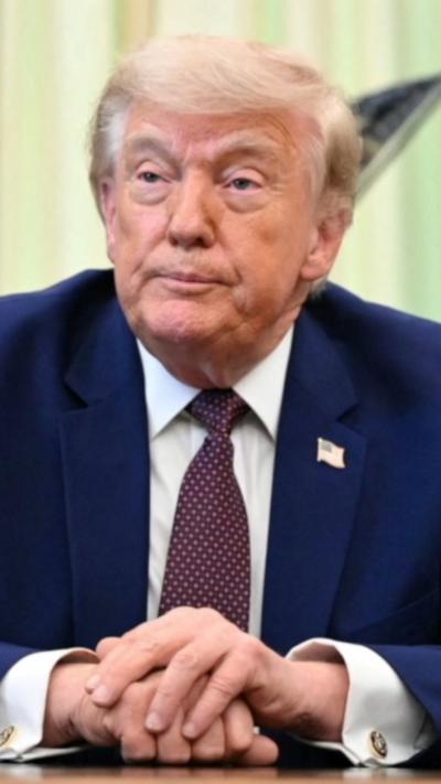 Donald Trump sat at a table with his hands clasped