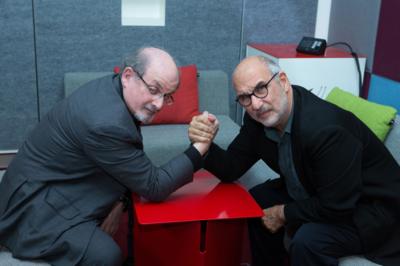 Salman Rushdie and Alan Yentob look at the camera as they arm wrestle