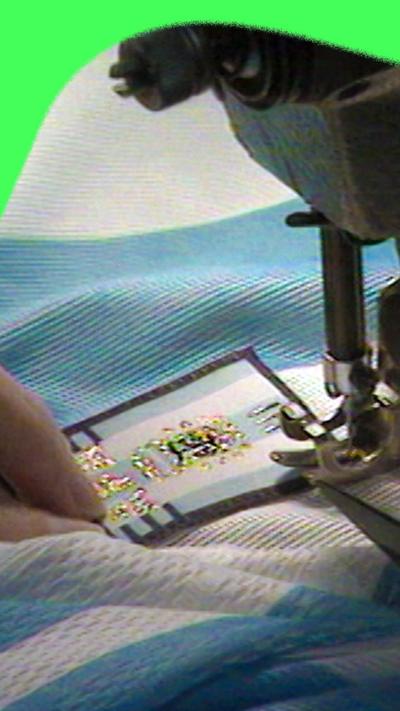 A close up of a 1998 Argentina shirt having a badge stitched to it using a sewing machine.