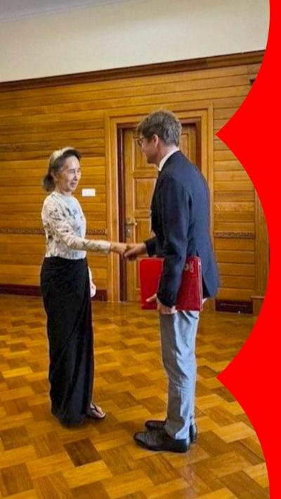 A woman on the left shakes a man's hand on the right.