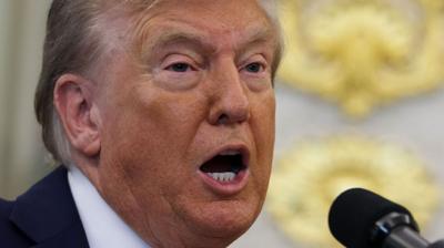 Trump speaks into a mic in the White House.