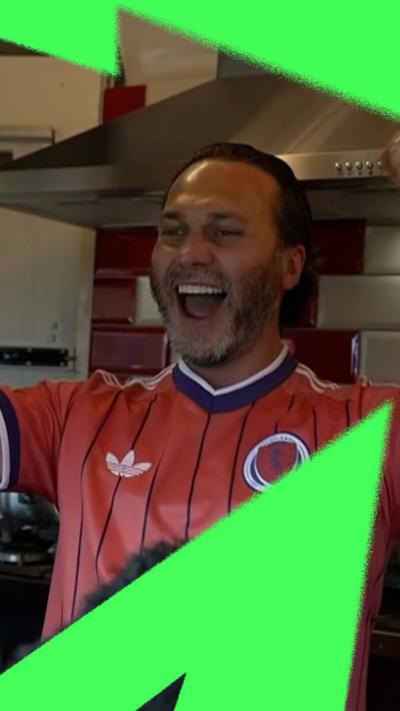 Man with Scotland top cheering