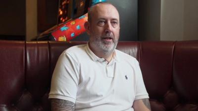 Mark Williams seated on a sofa