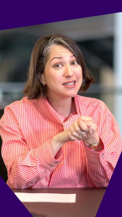 Teleri Glyn-Jones in a red and white striped shirt looking at the camera. She has brown hair cut into a bob, and she holds her hands in front of her.