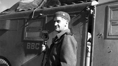 Greyscale image of war correspondent Denis Johnston holding a 91ȱ microphone.