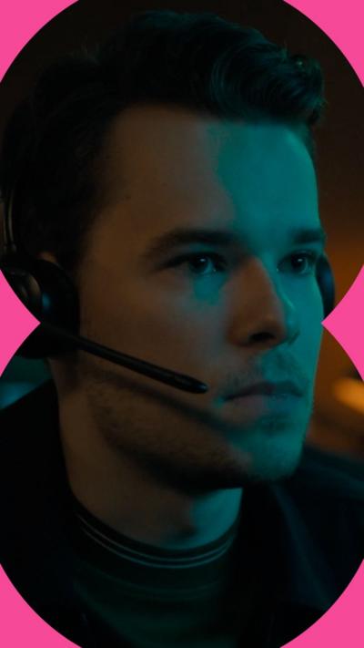 Man with dark hair wearing a headset stares to the right of the screen.