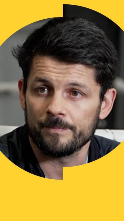 Retired boxer Stephen Smith wears a blue top under a black sport pullover and looks slightly to his right.