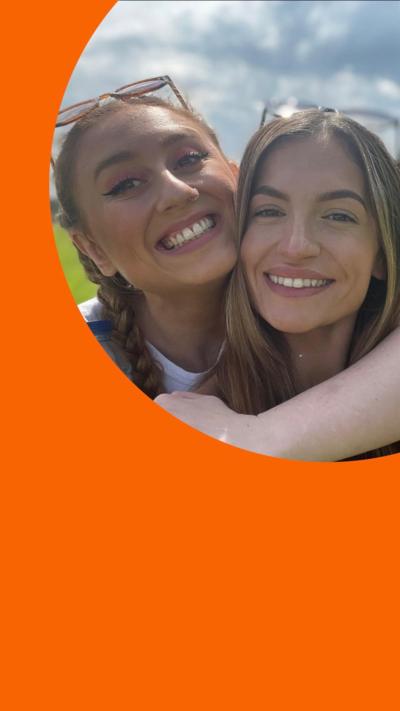 Two women, Daisy and Georgia, smile while embracing