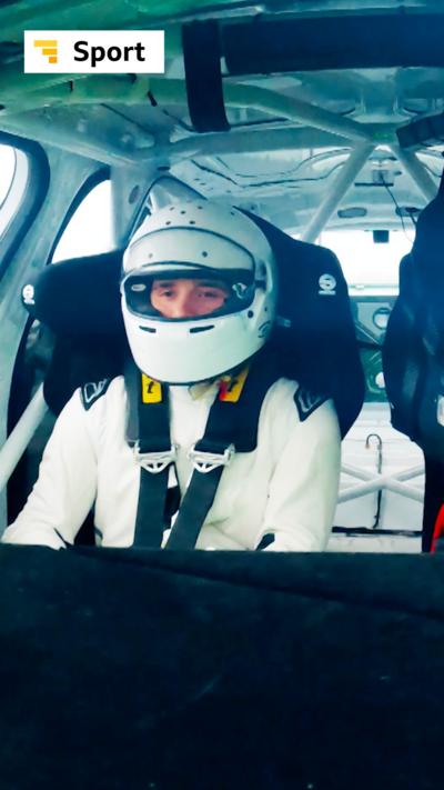 Brooklyn Beckham sat in the passenger seat of a race car wearing a white crash helmet