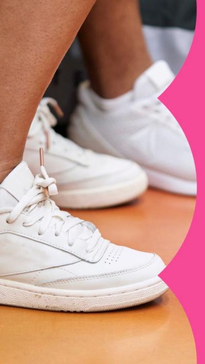 Close up of white trainers and bottom of someone's legs.