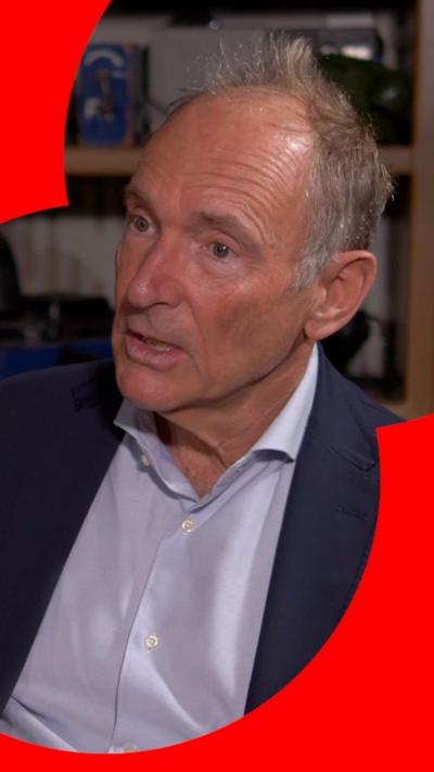 A man, Tim Berners-Lee, wears a light coloured shirt and dark suit jacket. He's sitting down talking to someone off camera.
