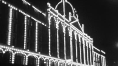 Department store lit up by Christmas lights at night