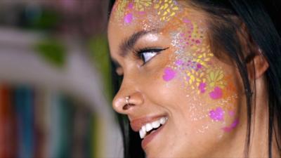 Image of woman wearing gold and pink face paint