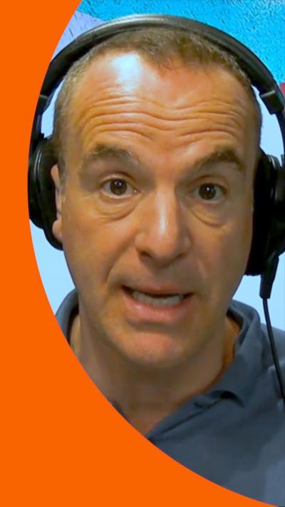 A man, Martin Lewis, wearing headphones, looking at the camera, with a green mic in front.