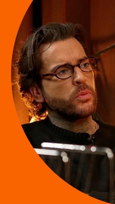 Pete wicks sitting down with his arms crossed 