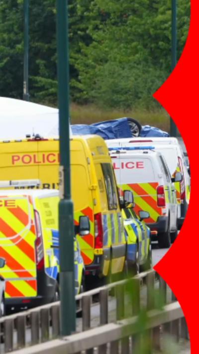 A row of police vans on a dual carriageway.