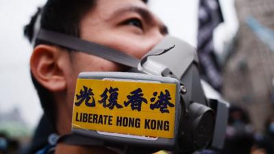 Protester wearing gas mask with 'Liberate HK' sticker