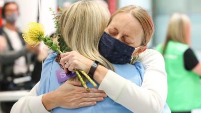 Two women hug at Sydney airport