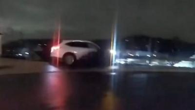 Car about to fall off a wall